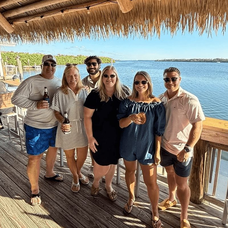 Friends smiling under a beach hut