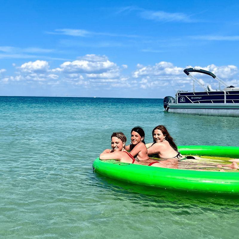 Women relaxing on inflatable float in ocean