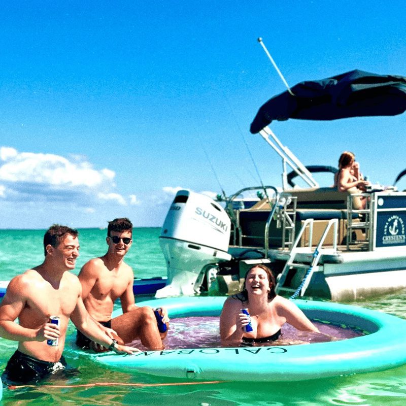 Friends laughing near a boat in ocean