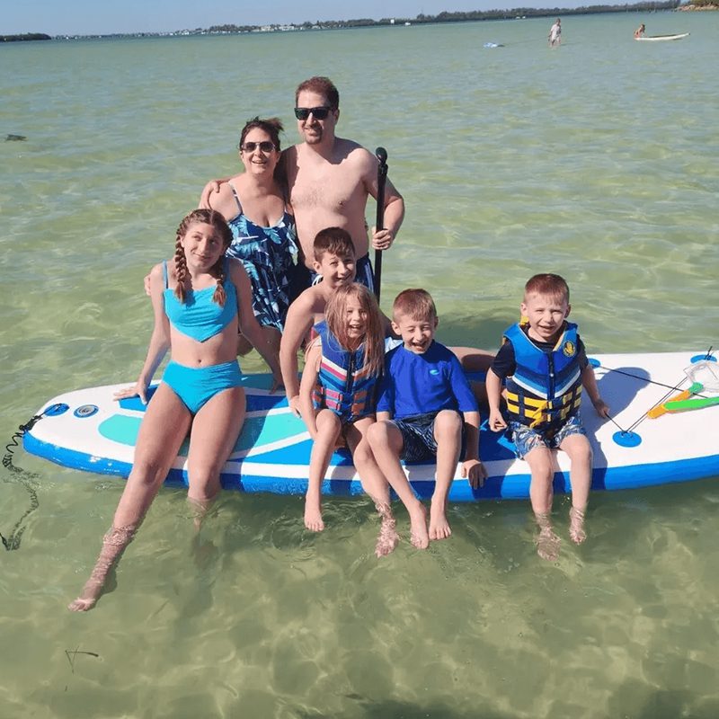 Group posing on paddleboard in water