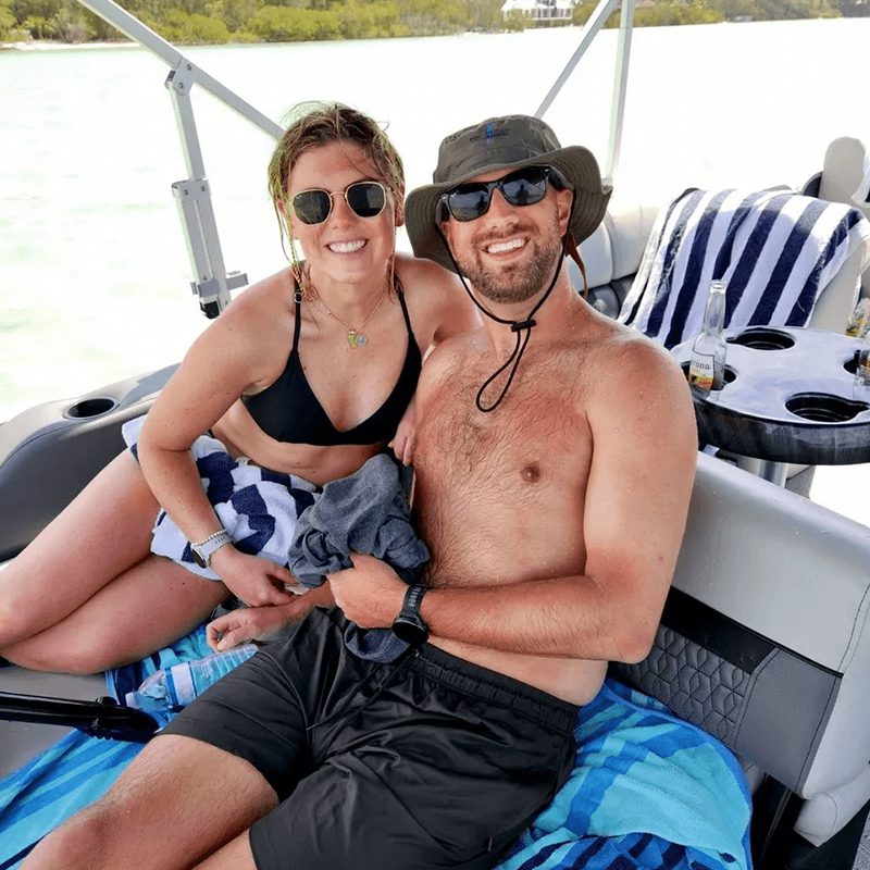 Two people sunbathing on a boat