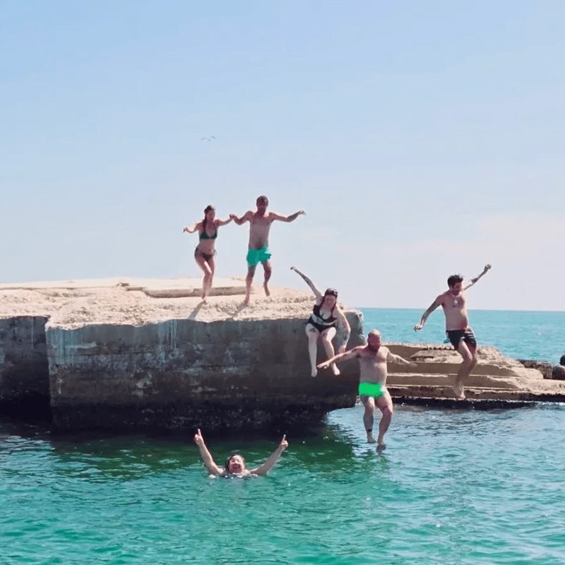 Group cliff diving into blue water