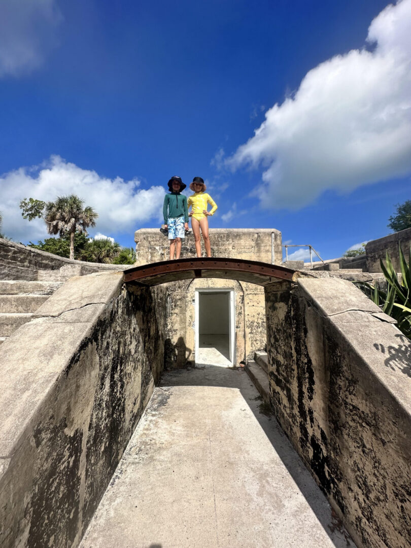 Two people standing on arched stone bridge