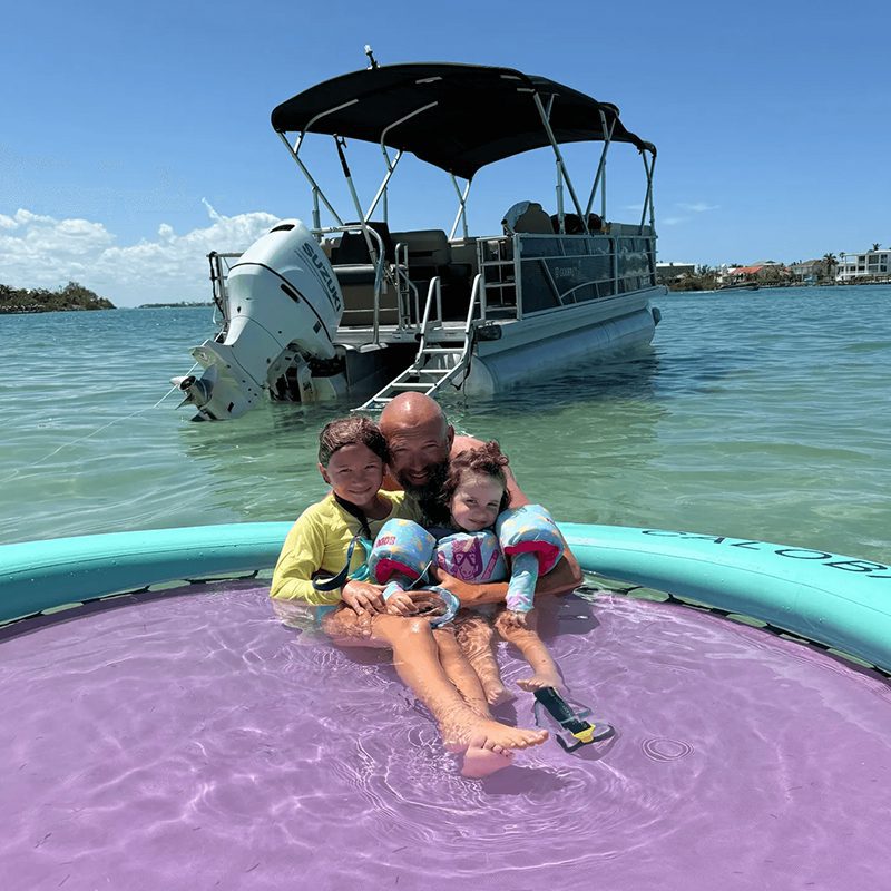 Family enjoying inflatable raft by boat
