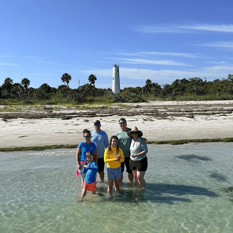 People at beach with lighthouse background