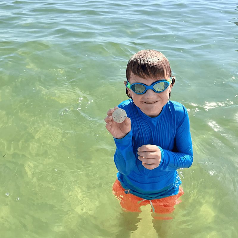 Boy wearing goggles and blue swim shirt