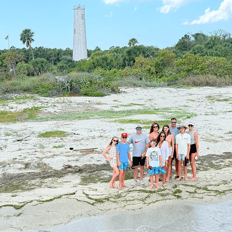 Family posing by seaside lighthouse
