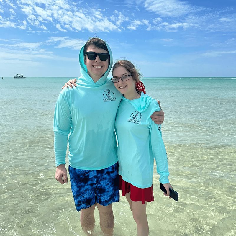Two people in turquoise hoodies at beach