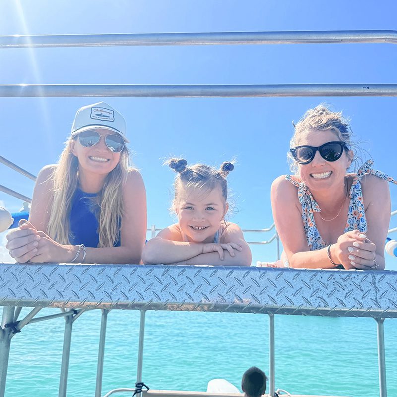 Three people smiling on a boat