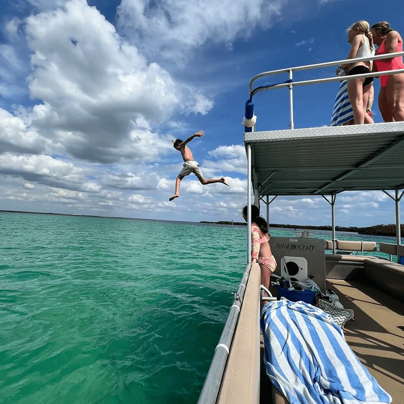 Person jumping off boat into lake
