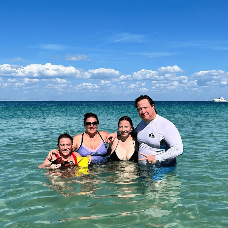Family posing in clear blue water