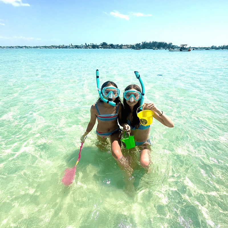 Children playing with snorkeling gear at beach.