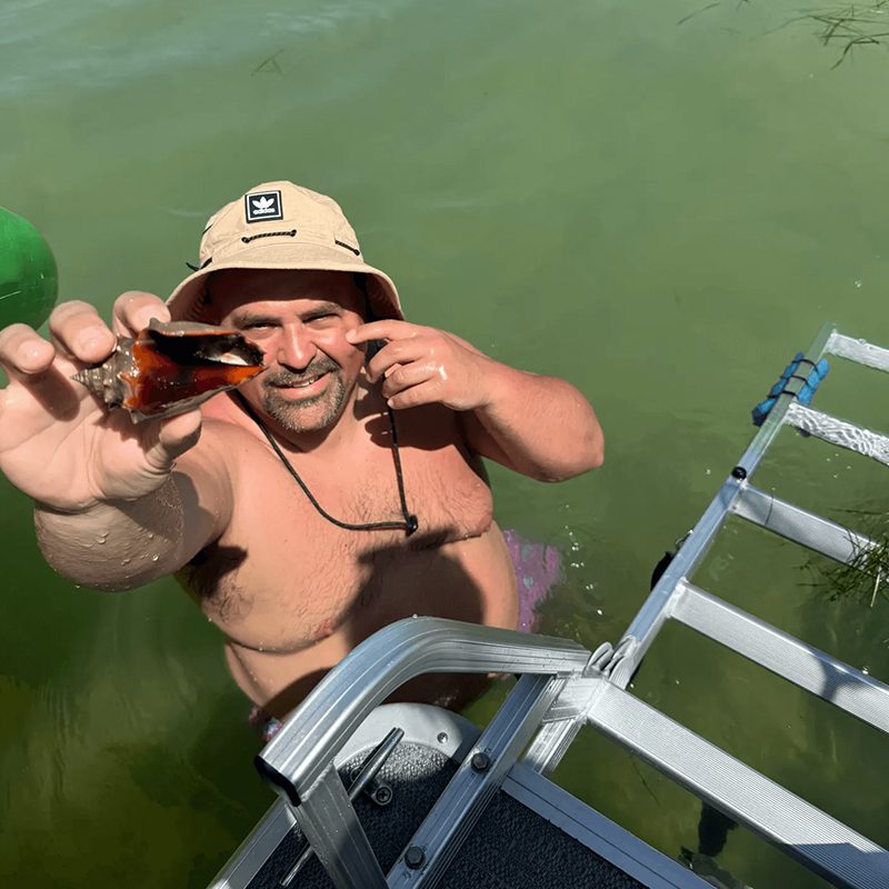 Man holding seashell in water