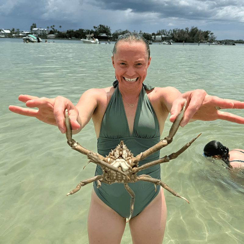 Woman holding starfish in water