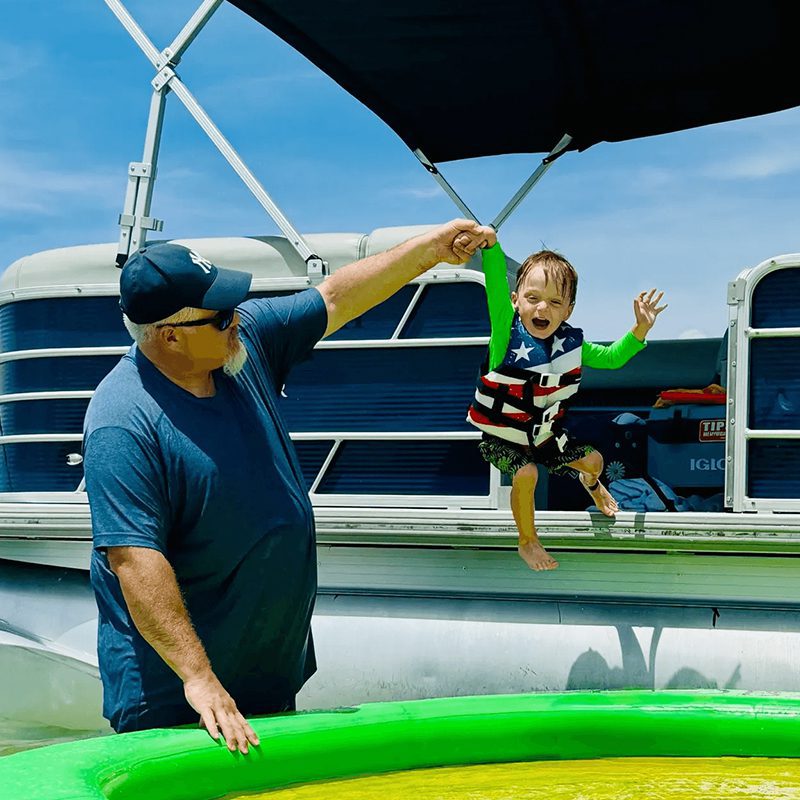 Man helping child jump off boat