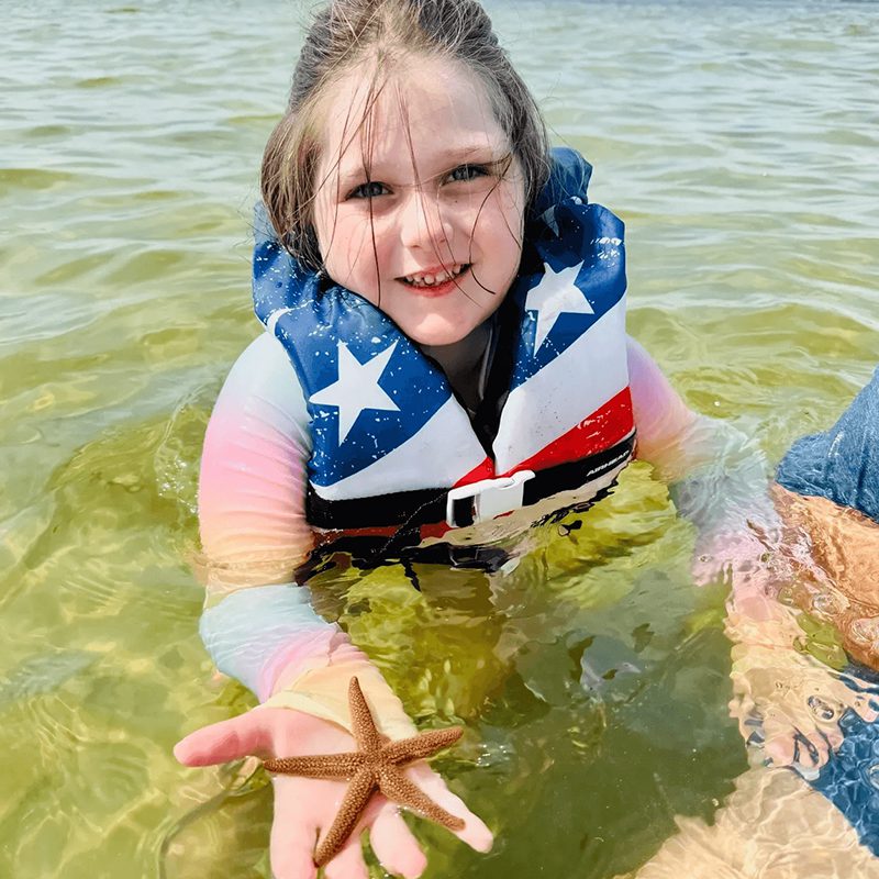 Girl with starfish at beach