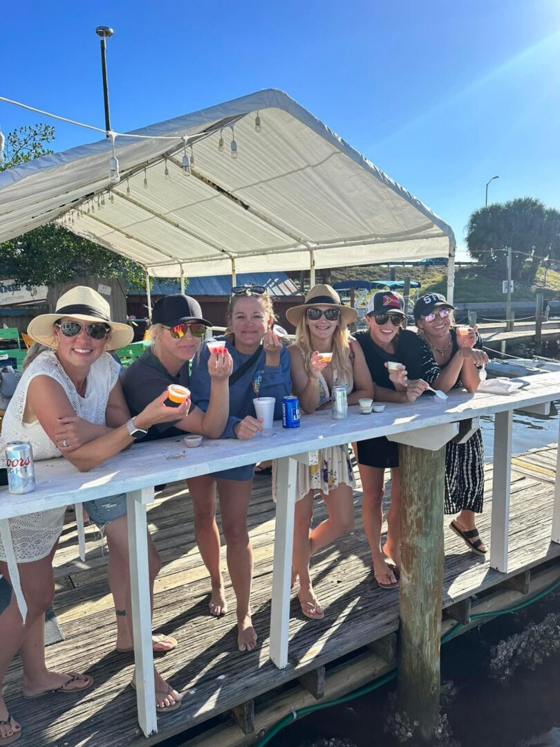 Group of women enjoying drinks on waterfront dock