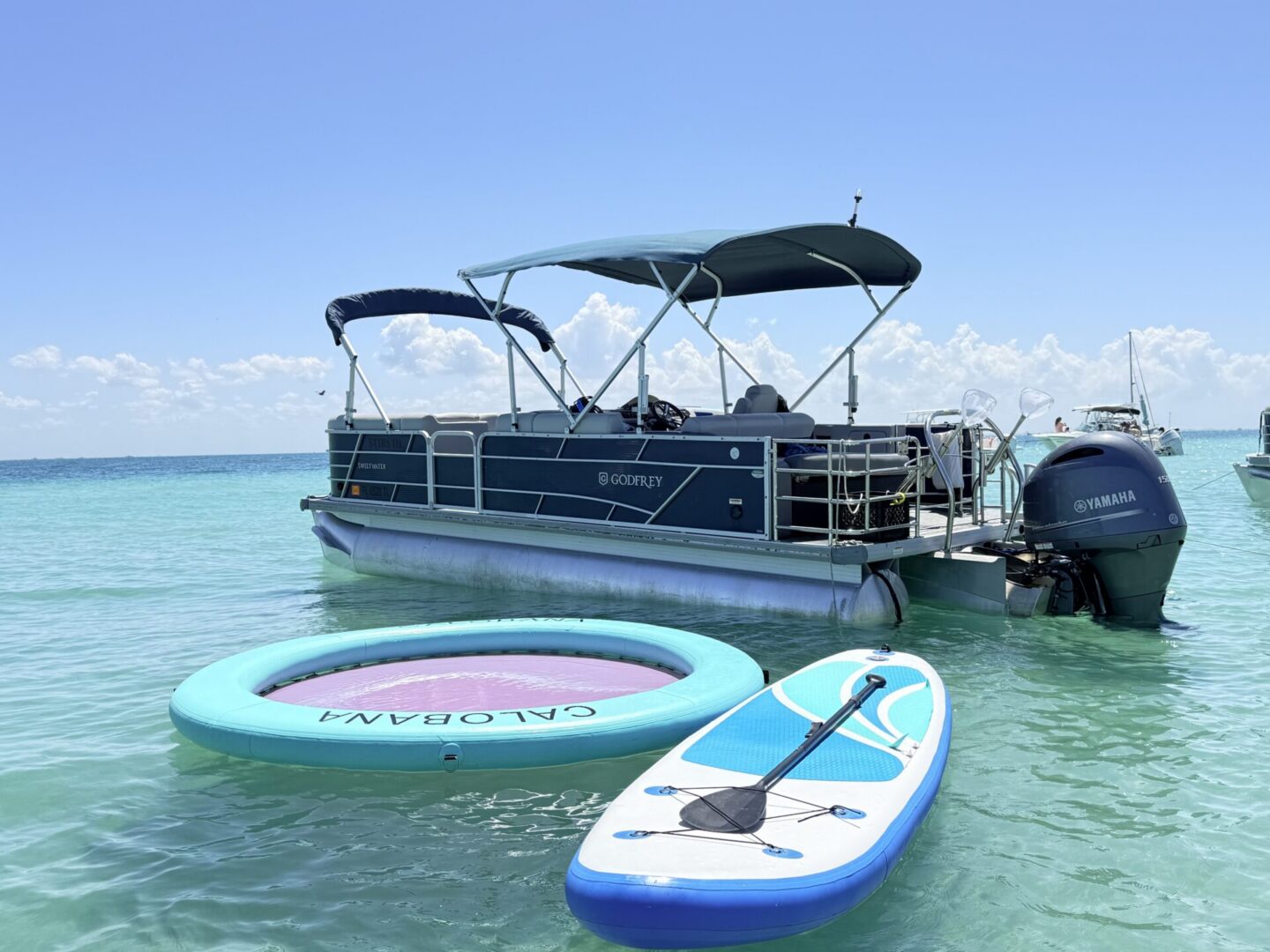 Pontoon boat with inflatable ring and paddleboard
