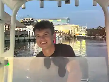 Person smiling on a boat at sunset