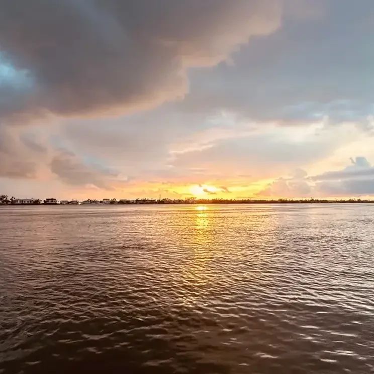 Cloudy sunset reflecting on ocean water